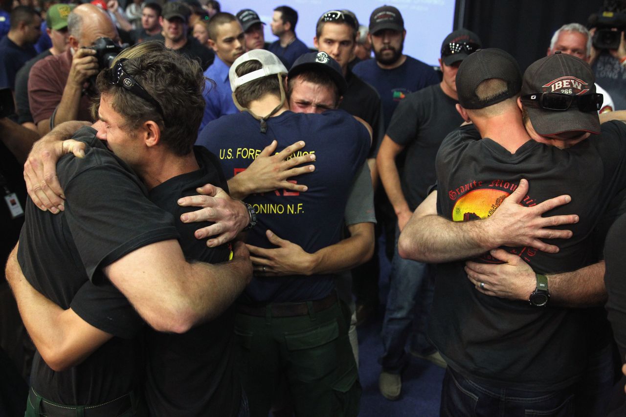Local firefighters embrace on July 1 at a memorial service in Prescott.