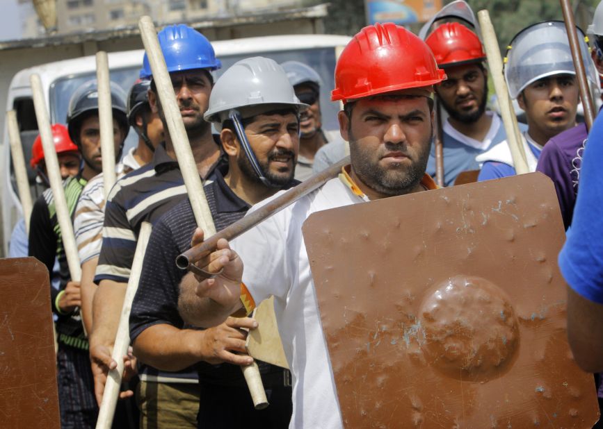 Supporters of President Morsy hold sticks and wear protective gear during training outside a mosque in Cairo on July 2.