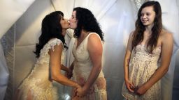 Andrea Taylor, left, and Sallee Taylor kiss during their wedding in West Hollywood, California, on Monday, July 1, as Sallee Taylor's daughter Grace Meier, right, looks on. The city of West Hollywood offered civil marriage ceremonies for same-sex couples free of charge Monday. 