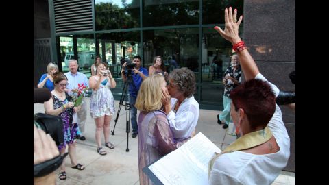 Naomi Hendrix, right, and Rio Waller kiss right after they are pronounced married in Fresno on June 1.