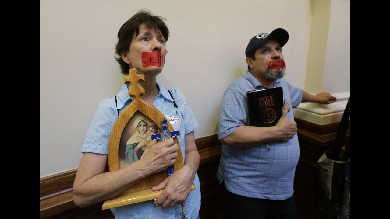 Anti-abortion demonstrators taped the word "life" over their mouths as they stood in the rotunda of the state Capitol in July 2013.