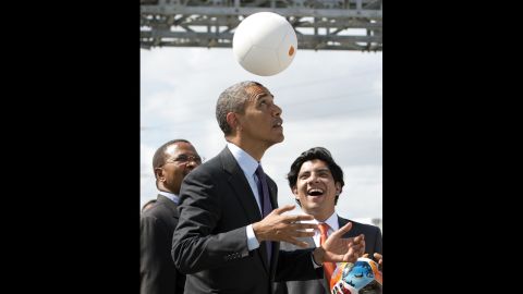 Tanzania's president, left, watches as Obama plays with the energy-generating soccer ball at the Symbion Power Plant on July 2. "I don't want to get too technical, but I thought it was pretty cool," Obama said of the ball that harnesses kinetic energy to provide power.<br />