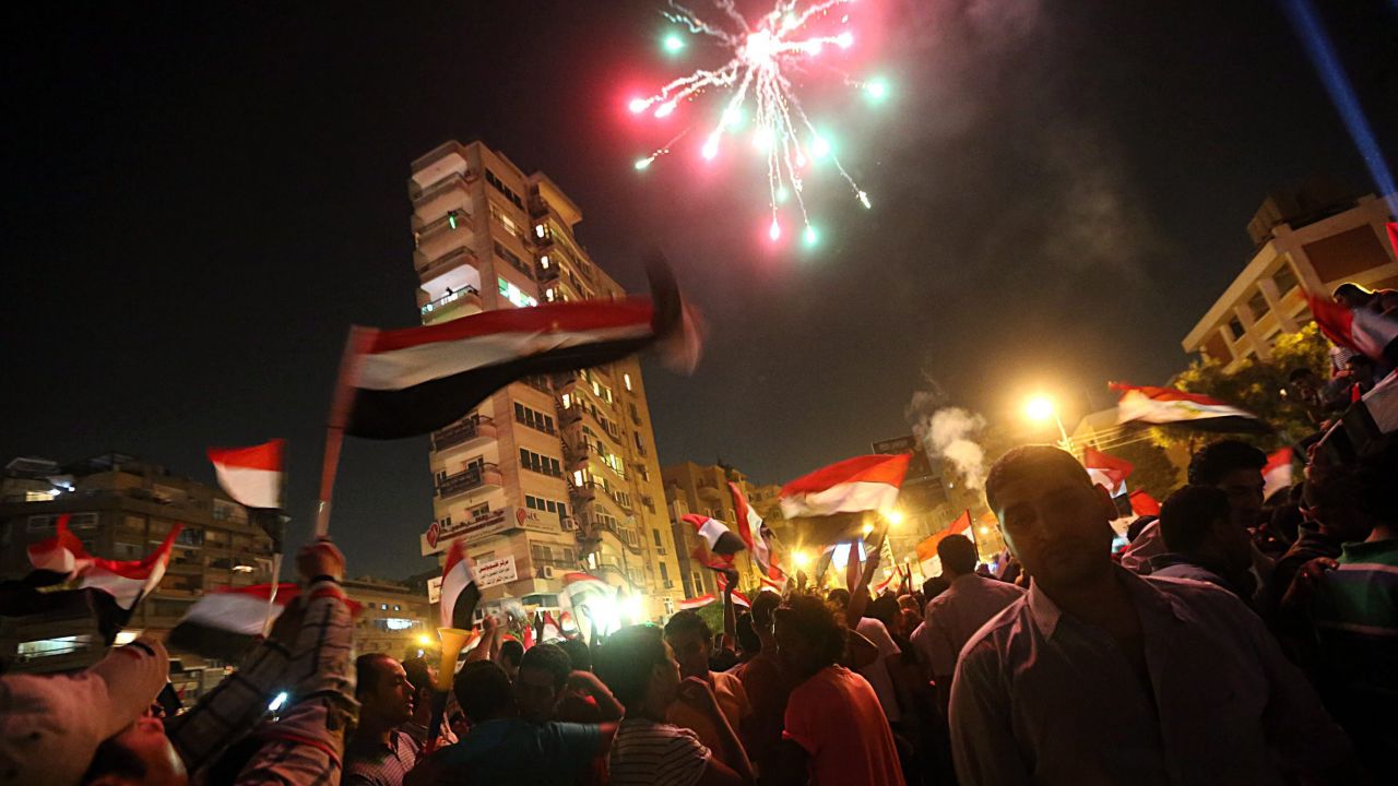 Fireworks go off as protesters gather in the streets outside the presidential palace in Cairo on July 2.
