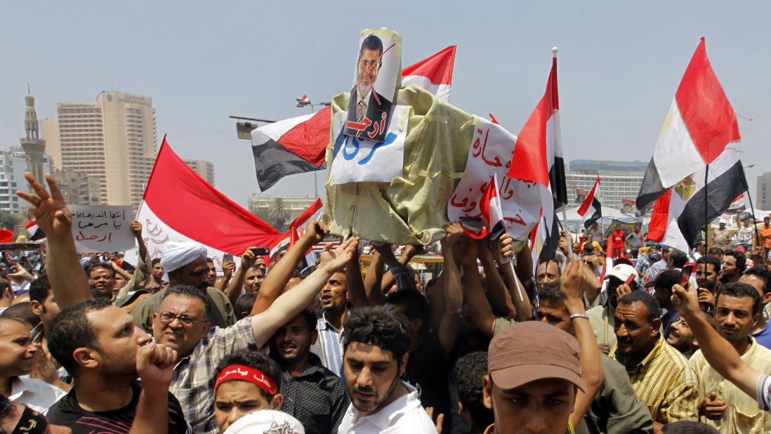 Opponents of Morsy shout slogans as they carry a symbolic coffin during a protest in Tahrir Square on July 3.