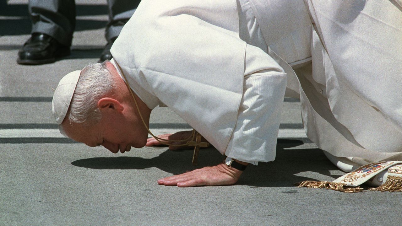 Juan Pablo II besa el suelo al llegar a Auckland, Nueva Zelanda, en noviembre de 1986.