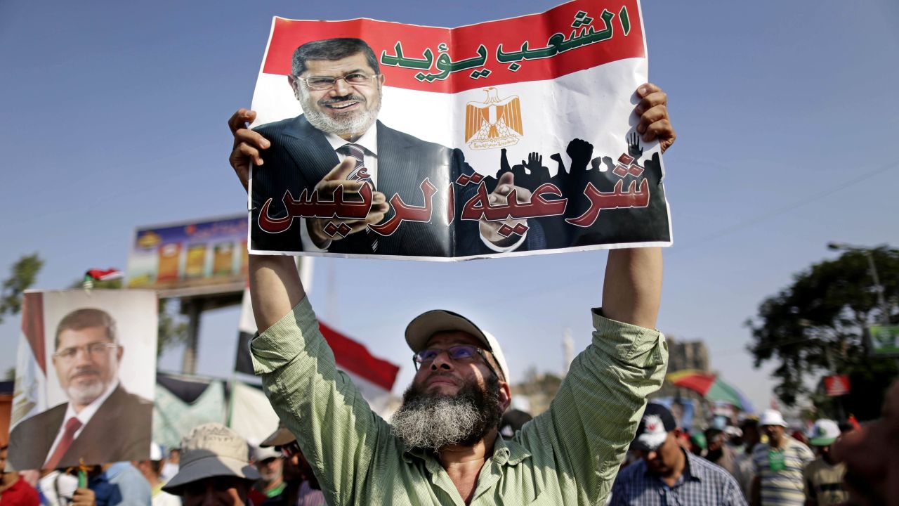 A supporter of Morsy holds a poster that reads, "The people support legitimacy for the president," during a rally in Cairo on July 3.