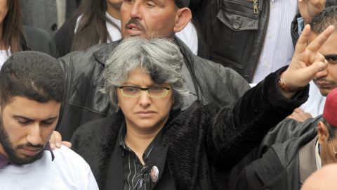 Belaid's widow, Basma Khalfaoui, flashes the sign for victory as Tunisians gather at the tomb of her late husband in Tunis in March. Few Tunisians had probably heard of Khalfaoui before her husband's death, but she has attained rock star status since then.