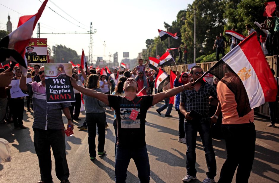 Opponents of Morsy wave national flags during a protest outside the presidential palace in Cairo on July 3.