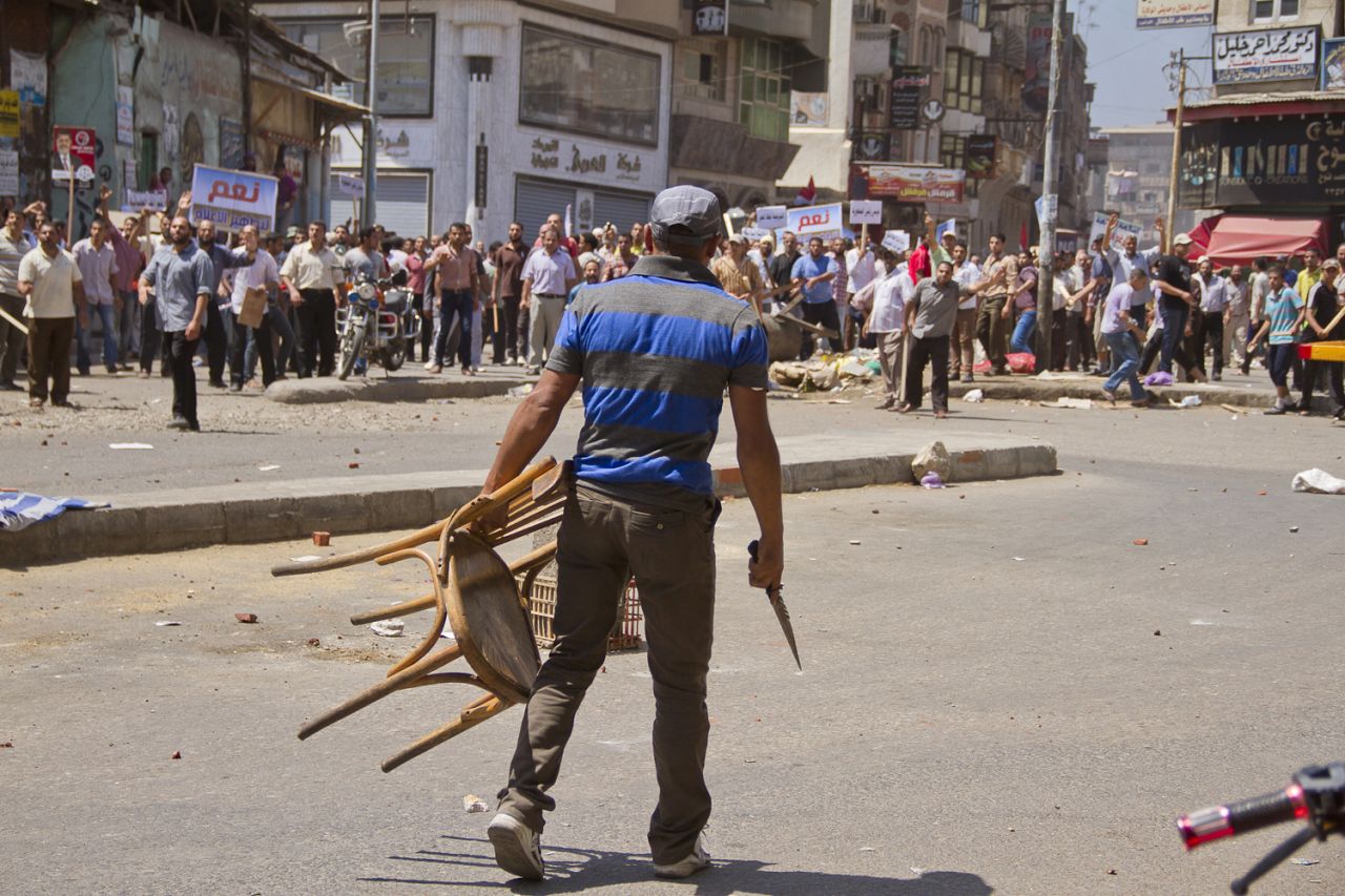 An opposition protester holds a chair and knife during clashes between supporters and opponents of Morsy on July 3 in downtown Damietta, Egypt, which is north of Cairo near the Mediterranean Sea.