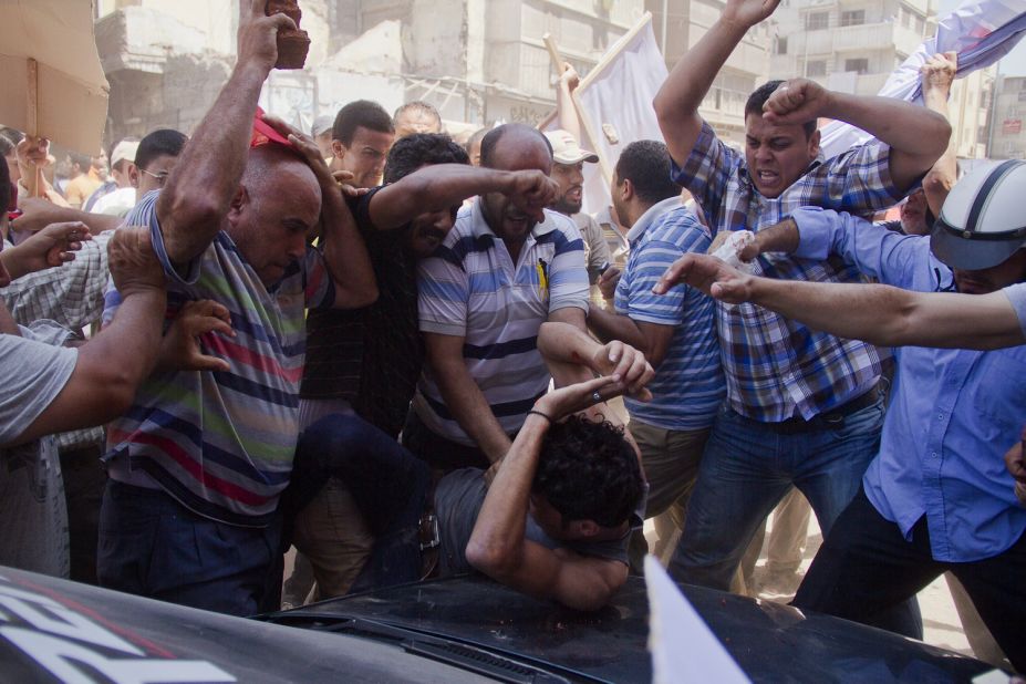An opposition protester is beaten by pro-Morsy demonstrators during clashes in Damietta on July 3.