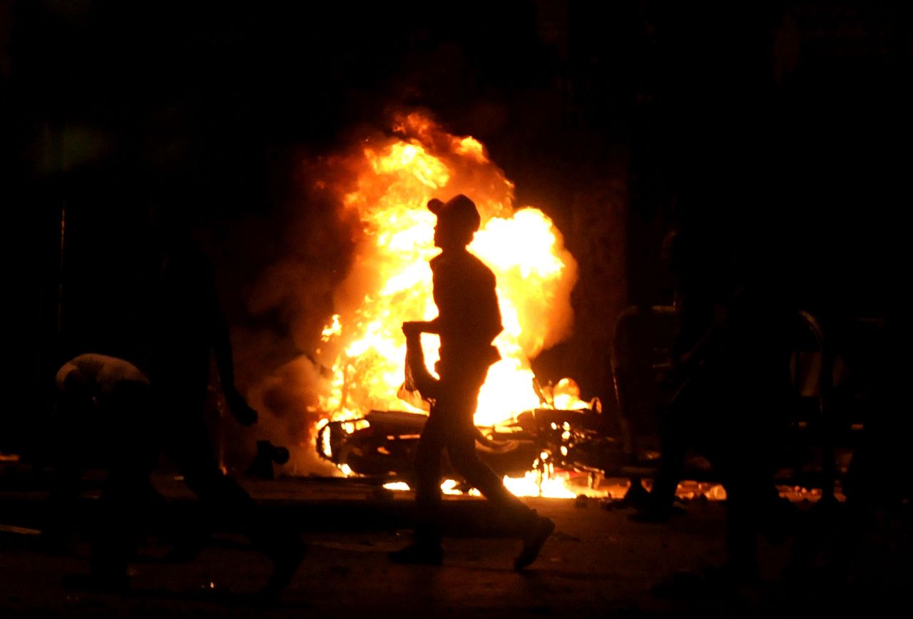 A protester runs past a fire raging during clashes in Giza, Egypt, early on July 3.