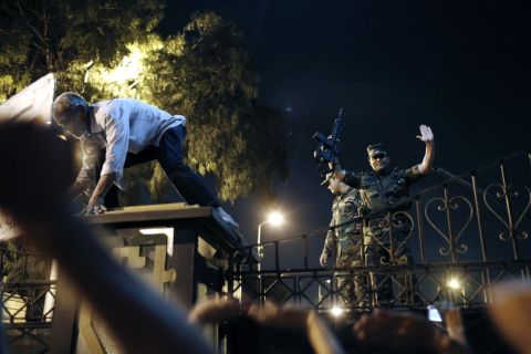 An officer gestures to protesters at the gates of the Republican Guard headquarters in the suburb of Nasr City on July 3. The Egyptian military gave Morsy a 48-hour ultimatum on Monday to accommodate his opponents with a power-sharing agreement or be pushed aside.