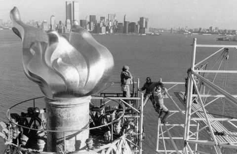 Workers remove scaffolding from around the statue's torch after restoration work in 1985.