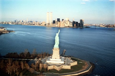 The New York Harbor and the World Trade Center building are seen behind the statue in 1980.