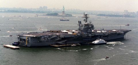 The aircraft carrier USS John F. Kennedy is anchored in New York Harbor near the Statue of Liberty in 2000.