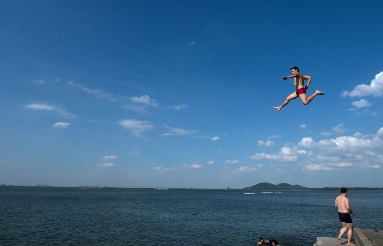 A man jumps into East Lake in Wuhan, the capital of central China's Hubei Province, on Wednesday, July 3.