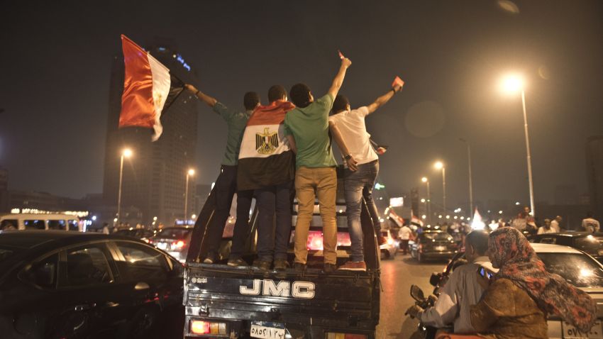 Egyptian youths on police vehicle celebrate in Cairo on July 3, 2013 after a broadcast confirming that the army will temporarily be taking over from the country's first democratically elected president Mohammed Morsi. In their tens of thousands, they cheered, ignited firecrackers and honked horns as soon as the army announced President Mohamed Morsi's rule was over, ending Egypt's worst crisis since its 2011 revolt.