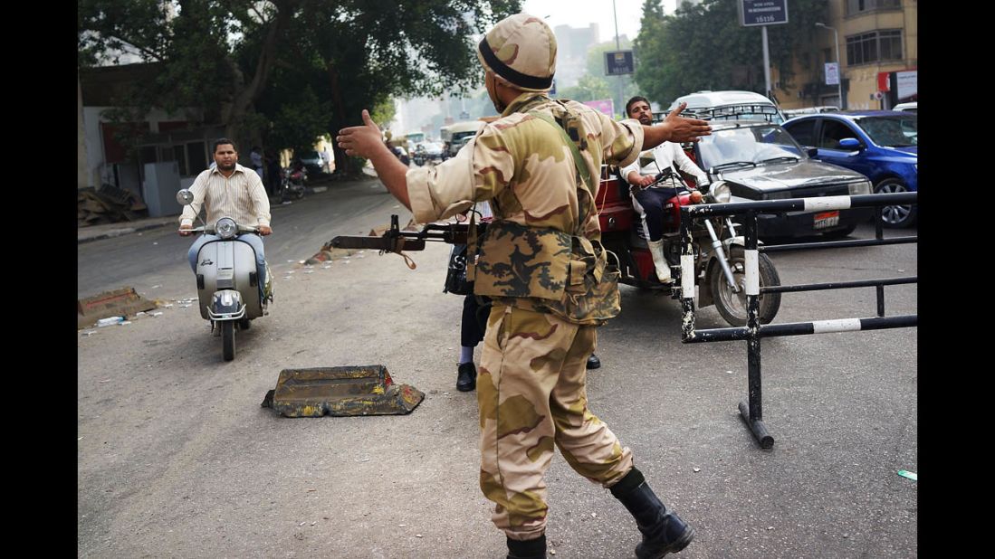 A member of the Egyptian military redirects traffic on July 4 at a roadblock in Giza.