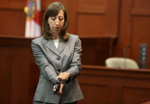 Firearms analyst Amy Siewert from the Florida Department of Law Enforcement answers questions from the prosecution while holding Zimmerman's gun on July 3. Siewert examined the gun and said Zimmerman had one bullet ready to fire in the chamber as well as a fully loaded magazine when the shooting occurred. 