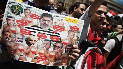 A celebrant bears a  poster on July 4 showing Mohamed Morsy surrounded by leading Muslim Brotherhood figures as babies.
