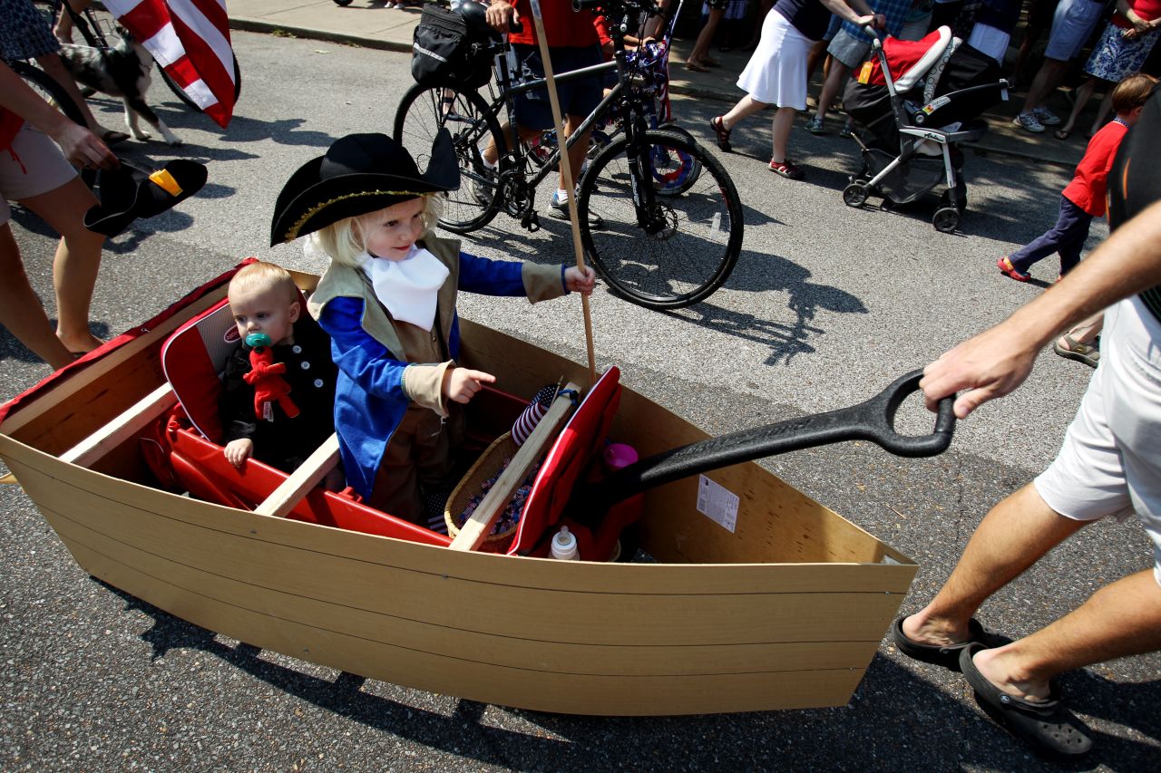 Emma Winkler, 3, points as she re-enacts George Washington's crossing of the Delaware River while being pulled down Carr Avenue in Memphis with her 11-month-old sister, Elizabeth Winkler.