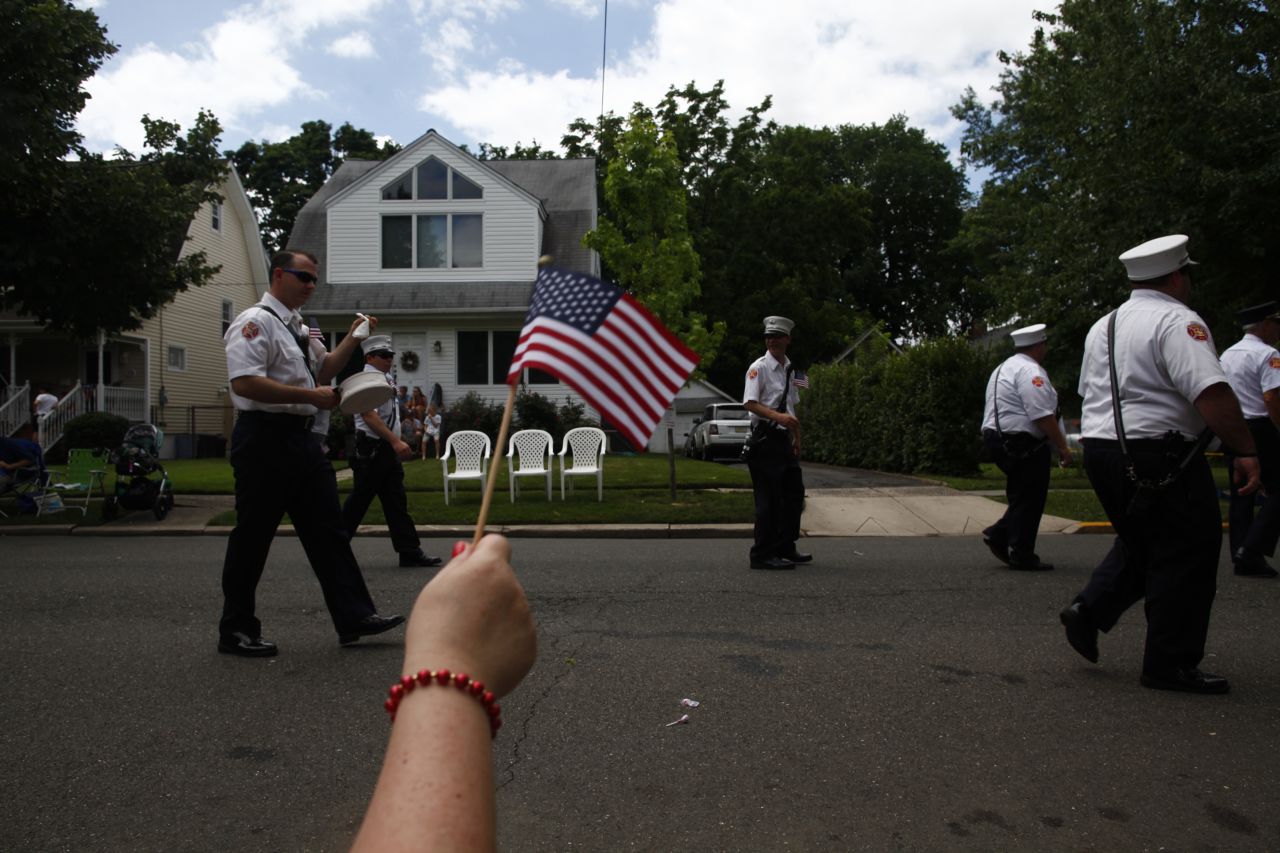 An observer waves an American flag during the parade in Ridgefield Park.
