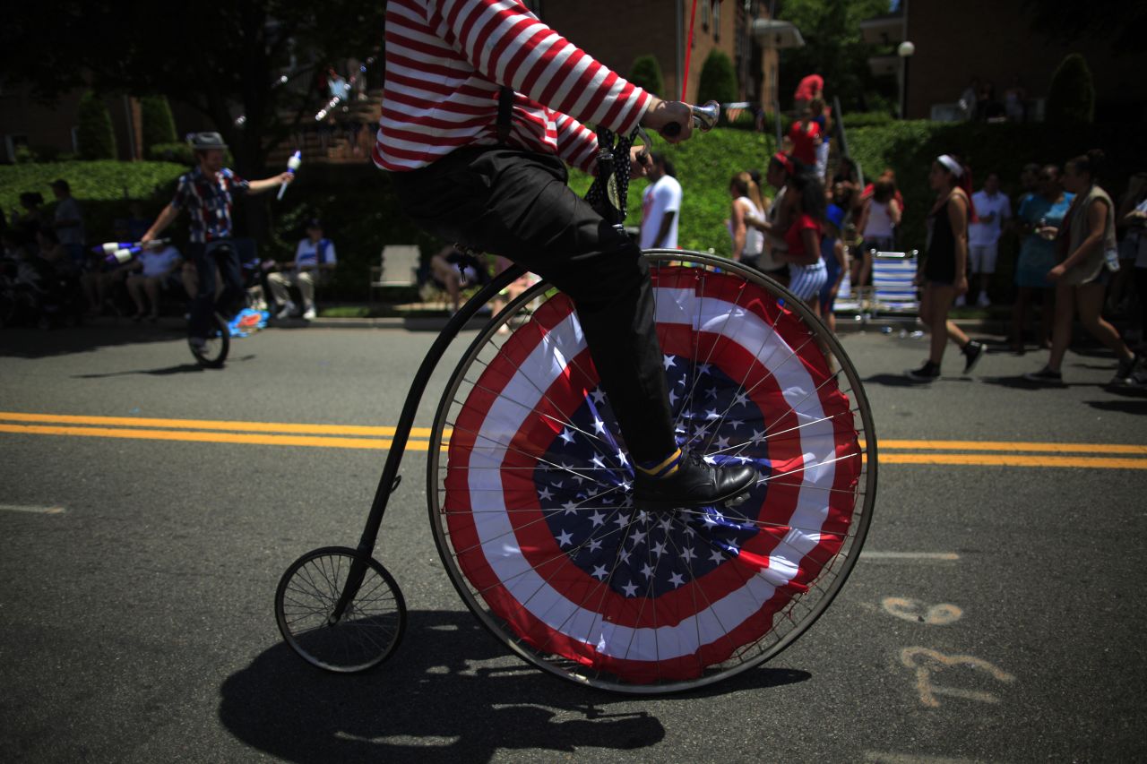 A parade participant rides a penny farthing, or high-wheel bicycle, down the street in Ridgefield Park.
