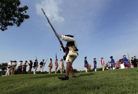 Ed Lunderman, a member of a Living History Musket Detail, fires his weapon to represent 