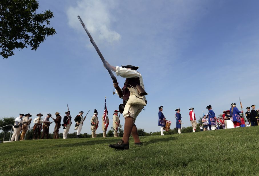 Ed Lunderman, a member of a Living History Musket Detail, fires his weapon to represent "the shot heard around the world" during a Fourth of July ceremony at Fort Sam Houston National Cemetery in San Antonio.