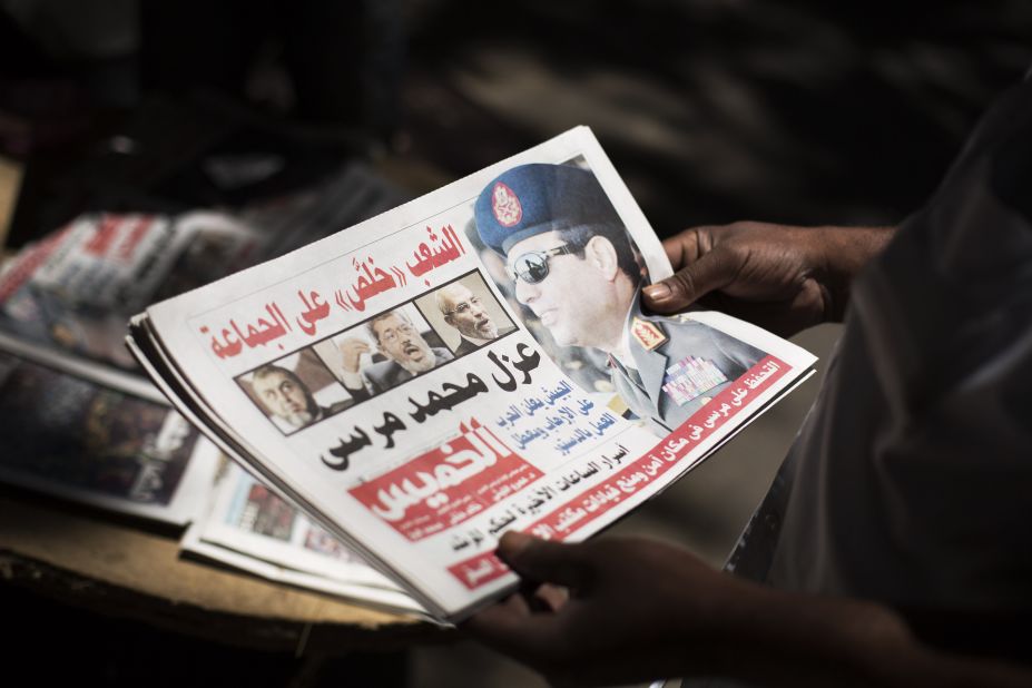 A man holds a newspaper near Mesaha Square in Cairo on July 4.