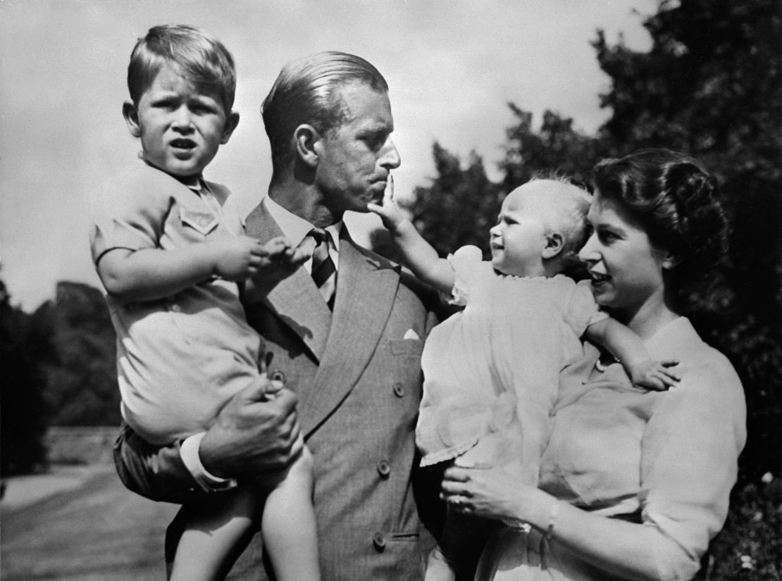 Queen Elizabeth II and Prince Philip, the Duke of Edinburgh, with a young Prince Charles and a baby Princess Anne.