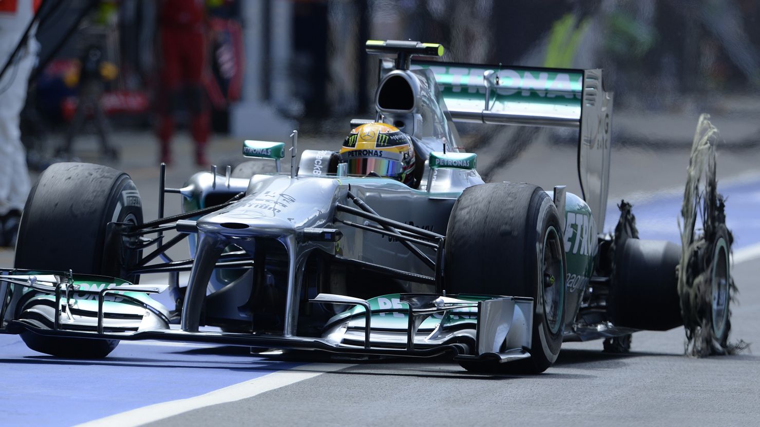 Lewis Hamilton pits with a shredded left rear tire after his high speed blow out at Silverstone in the British GP.