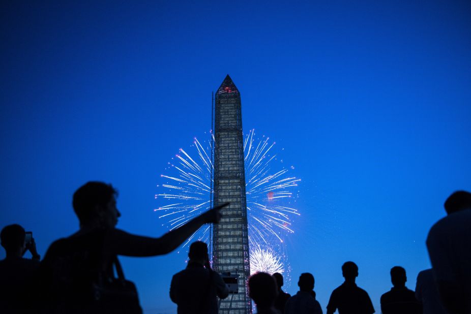 People watch fireworks burst behind the Washington Monument on the National Mall in Washington on Thursday, July 4. People across the United States gathered on Thursday to celebrate Independence Day with parades, picnics and fireworks.