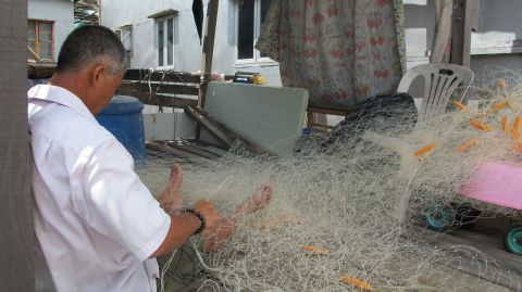 A local fisherman uses home-knitted nets after the government banned trawling.