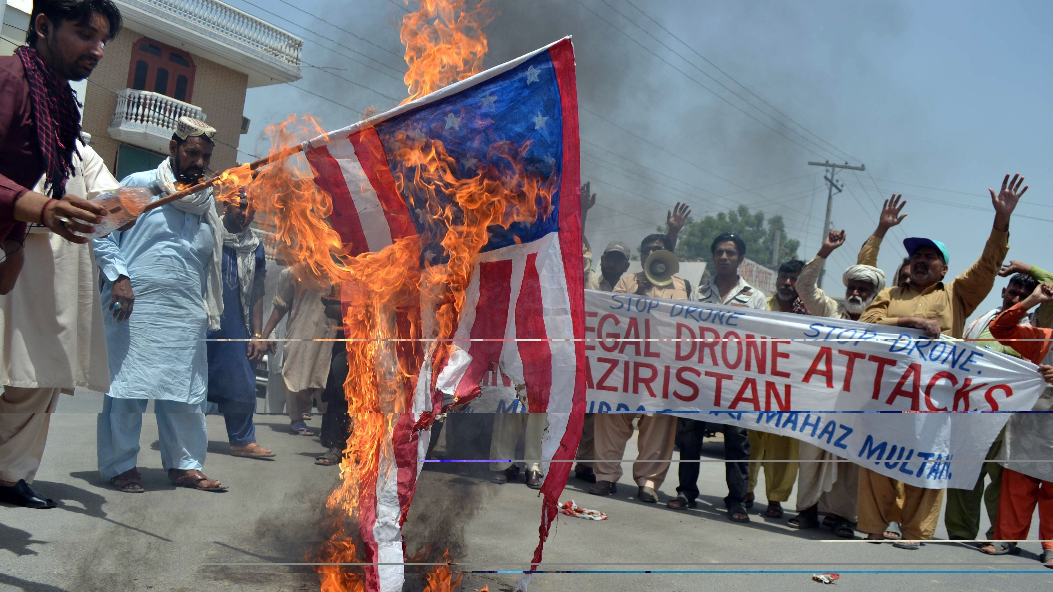 Pakistani anti-drone protesters from the United Citizen Action torch a U.S. flag in Multan on May 30, 2013. 