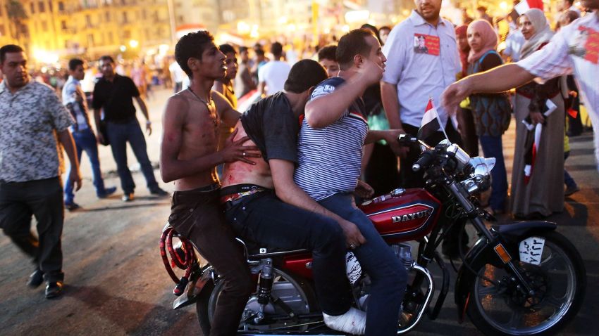 CAIRO, EGYPT - JULY 06: An anti-Mohammed Morsi protester is attended to after allegedly being shot by Muslim Brotherhood supporters in Tahrir Square during fighting between the two camps on July 5, 2013 in Cairo, Egypt. Adly Mansour, chief justice of the Supreme Constitutional Court, was sworn in as the interim head of state in ceremony in Cairo in the morning of July 4, the day after Morsi was placed under house arrest by the Egyptian military and the Constitution was suspended. (Photo by Spencer Platt/Getty Images)