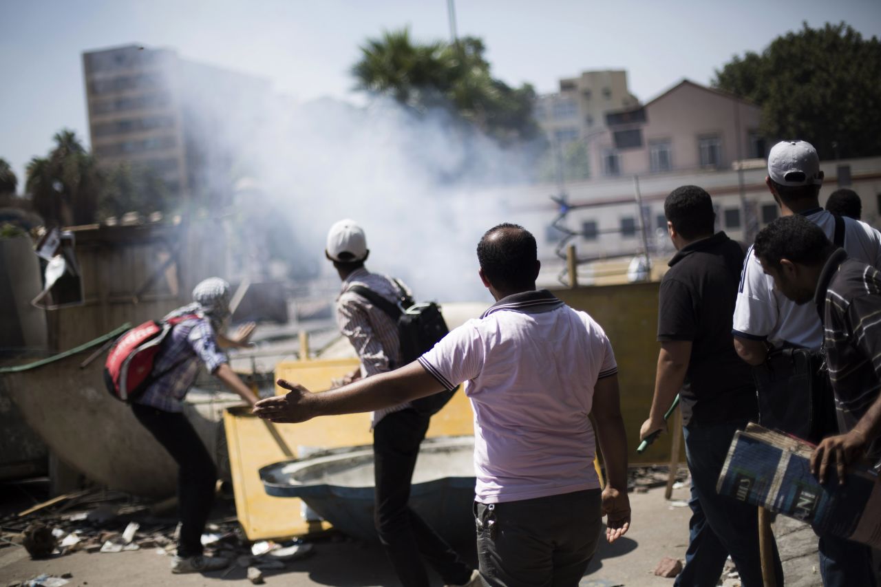 Morsy supporters react to an explosion during clashes with police officers on July 5 outside Cairo University in Giza.
