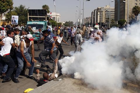 Protesters take cover from tear gas during clashes outside the headquarters of the Republican Guard in Cairo on July 5.
