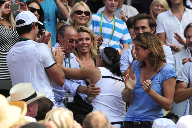 Bartoli embraces her father and former coach Walter. Her current coach, Amelie Mauresmo (right) was the last French winner of the Wimbledon women's singles title. 