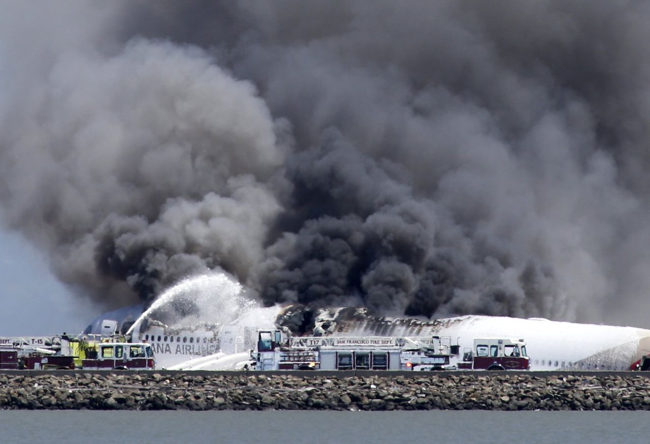 Los bomberos tratan de extinguir las llamas después de que el avión Boeing 777 de  Asiana Airlines se estrellara al intentar aterrizar en el Aeropuerto internacional San Francisco el sábado 6 de julio.