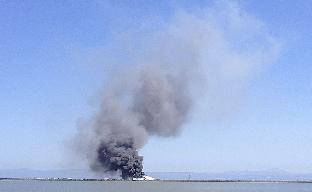 Smoke rises from the crash site across the San Francisco Bay on July 6.