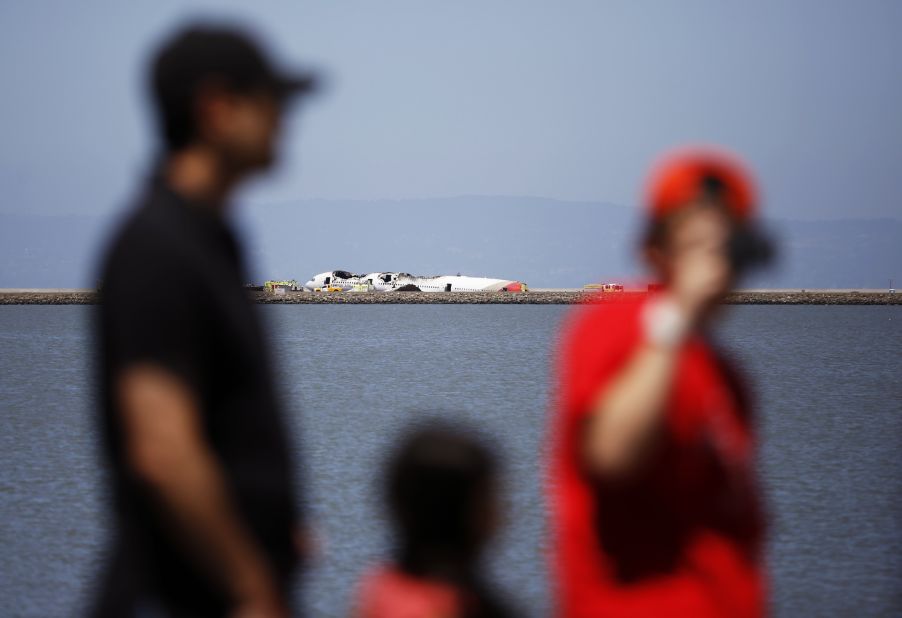 People look over the wreckage across a cove in San Francisco Bay on July 6.