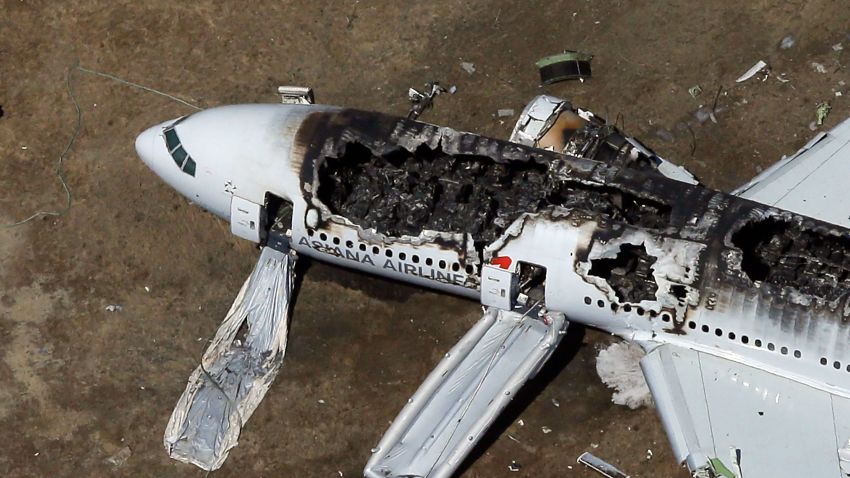  A Boeing 777 airplane lies burned near the runway after it crash-landed at San Francisco International Airport July 6, 2013 in San Francisco, California. An Asiana Airlines passenger aircraft coming from Seoul, South Korea crashed while landing, killing two people and injuring scores of others.