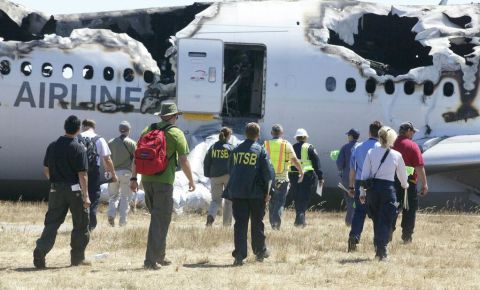 Investigators approach the crash in a handout photo released on July 7.