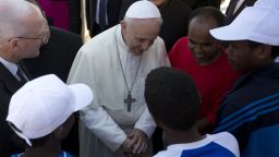 Pope Francis (C) greets migrants during his visit to the island of Lampedusa, a key destination of tens of thousands of would-be immigrants from Africa, during his visit on July 8, 2013