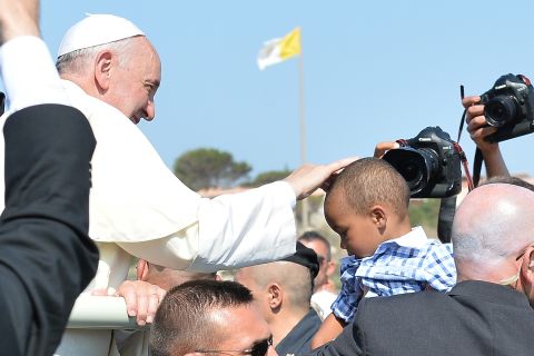 Pope Francis blesses a child as he arrives on the island. 