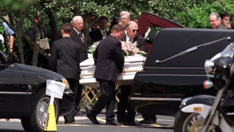One of the children's caskets is put into a hearse after the funeral.  