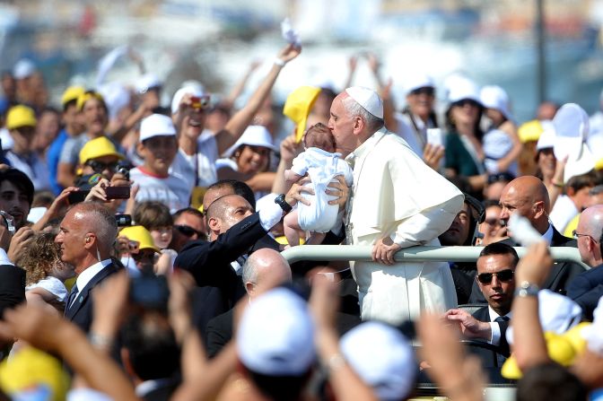 JULY 9 - LAMPEDUSA, ITALY: Pope Francis kisses a child as he arrived on the island of Lampedusa, gateway to Europe for many migrants fleeing Africa, on July 8. On his<a href="http://cnn.com/2013/07/08/world/europe/pope-lampedusa-refugees"> first pastoral visit of his papacy</a>, the pontiff prayed for refugees and migrants lost at sea. He used his visit to criticize what he called "global indifference" to the refugee crisis.
