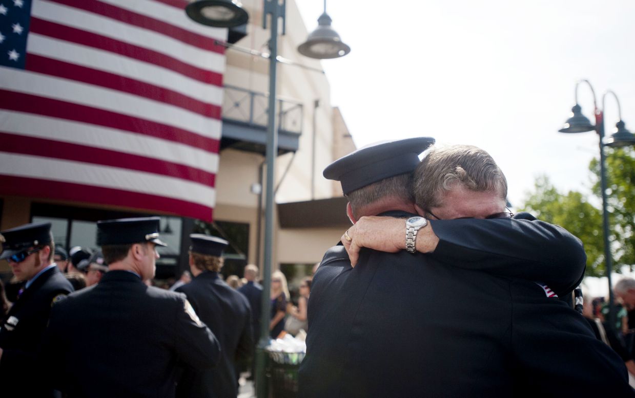 Chaplain Bob Ossler, right, hugs people at the Prescott Valley, Arizona, memorial service on July 9, honoring the fallen firefighters of the Yarnell Hill Fire. 