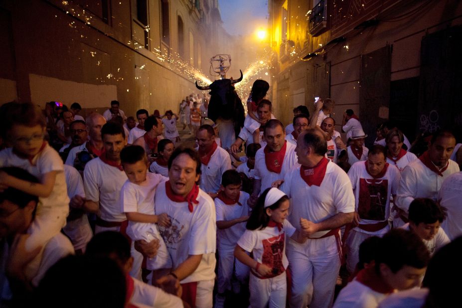 A flaming bull, or "toro del fuego," is run through the streets on July 9. 